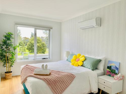 墨尔本The Daisy House - Family-friendly & top convenient location的一间卧室配有一张带花枕的床