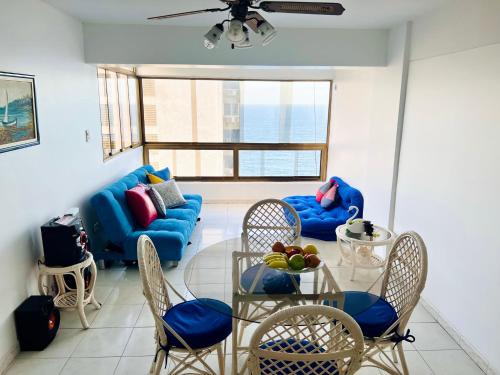 MacutoCasa de la Playa的客厅配有蓝色的沙发、桌子和椅子