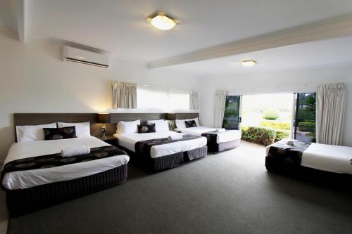 班达伯格塔卡尔万汽车旅馆的酒店客房设有三张床和窗户。