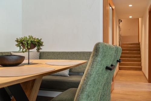 佩尔蒂绍Meerberg的一间带木桌和绿色椅子的用餐室