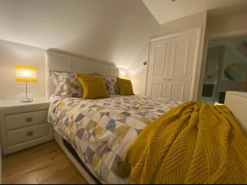 斯托昂泽沃尔德The Cotswold Stowaway, Perfect Luxurious Retreat!的一间卧室配有一张黄色棉被的床