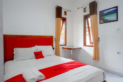 沃诺索博RedDoorz near Alun Alun Wonosobo 2的白色客房内的红色和白色床铺