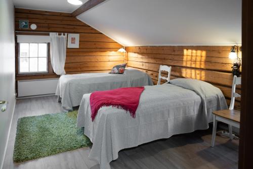 库奥皮奥Possakkatupa的木墙客房的两张床