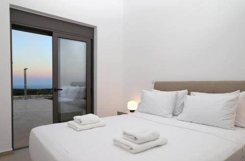 锡蒂亚Villa Tropicana, luxury villa with pool by Sternes Properties的卧室配有白色床和毛巾
