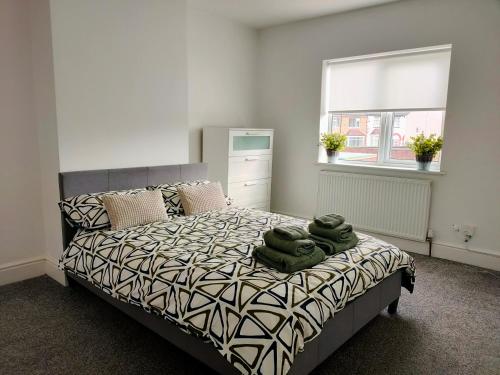 唐克斯特Wentworth Road Accomodation的一间卧室配有一张带绿毛巾的床