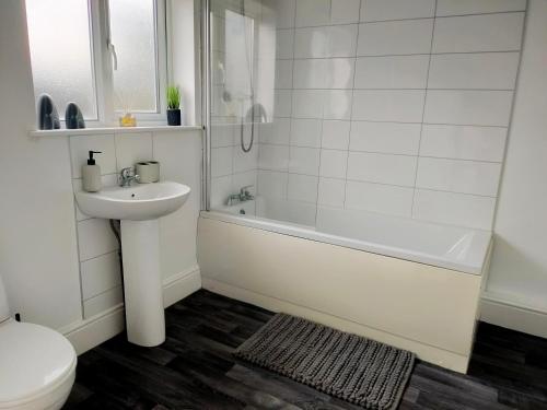 唐克斯特Wentworth Road Accomodation的一间带水槽、浴缸和卫生间的浴室