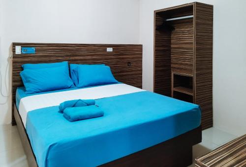 长滩岛RedDoorz at Sir G Hotel D'Mall Boracay的一张床上有蓝色枕头的睡床