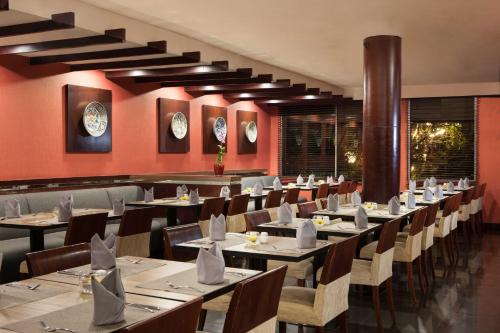 三宝垄桑提卡三宝垄酒店的一间在房间内配有桌椅的餐厅