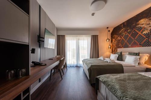 艾杰克Rókusfalvy Borhotel és Fogadó的酒店客房配有两张床和一张书桌