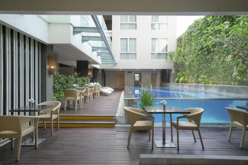 库塔库塔索啦丽思酒店的一间带桌椅的餐厅和一个游泳池