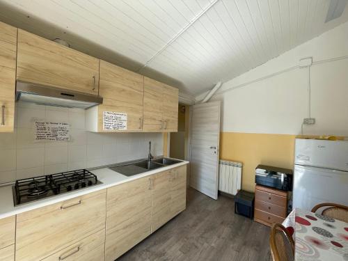 斯培西亚Casa Per Ferie San Giovanni Bosco的厨房配有木制橱柜和白色冰箱。