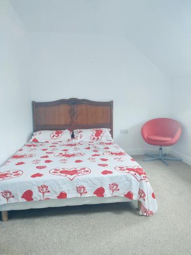 莱斯特Madif Ensuite的一间卧室配有一张床和一张红色椅子
