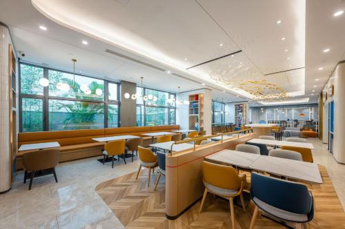 江门江门东站智选假日酒店的餐厅设有桌椅和窗户。