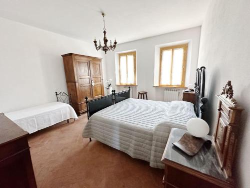 圣吉米纳诺Casale di Valle Mora的一间卧室设有两张床、一张桌子和窗户。