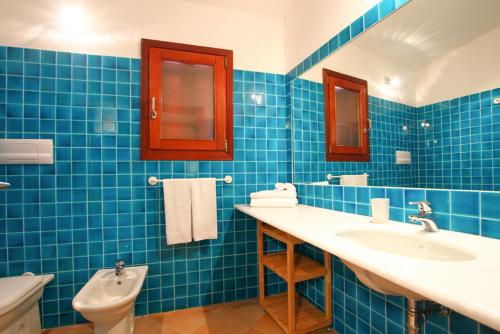 圣特奥多罗卡拉天堂公寓酒店的蓝色瓷砖浴室设有2个盥洗盆和1个卫生间