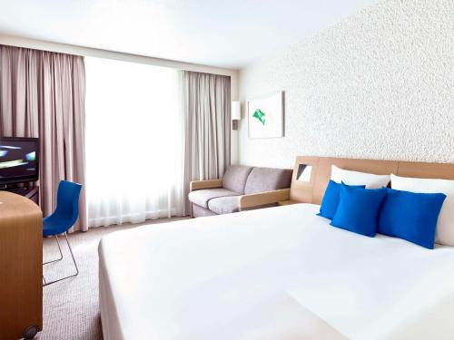 圣罗兰度瓦诺沃特尼斯机场卡普3000酒店的酒店客房配有一张带蓝色枕头的大床