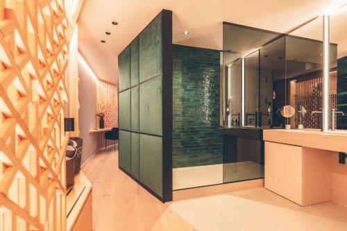 弗劳埃瑙Hotel Eibl-Brunner 4-Sterne-Superior的一间设有绿色玻璃墙的浴室