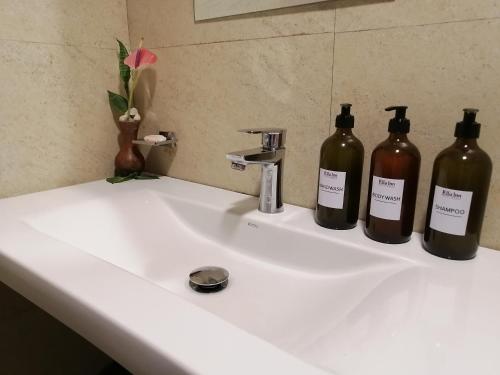 埃拉埃拉旅馆的浴室水槽里放着三瓶葡萄酒