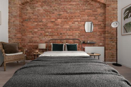 卡托维兹HARBOR APARTMENTS - Damrota的一间卧室设有一张床和砖墙