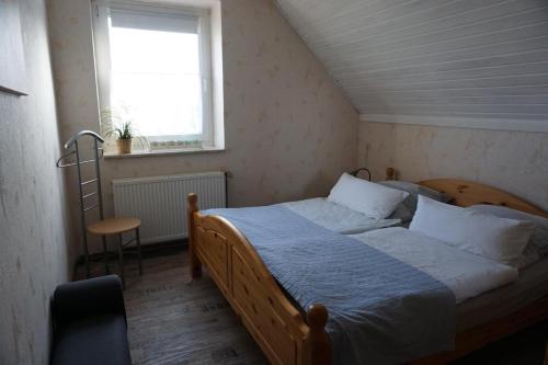 WinsenFerienwohnungen Bauernhof Beckmann的一间卧室设有一张床、一个窗口和一把椅子