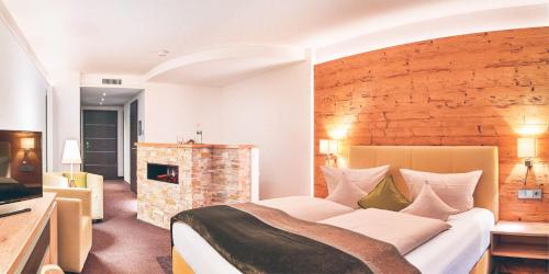 弗劳埃瑙Hotel Eibl-Brunner 4-Sterne-Superior的一间卧室设有一张大床和一个壁炉