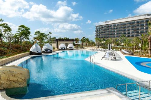 宫古岛Hilton Okinawa Miyako Island Resort的度假村的游泳池,酒店背景