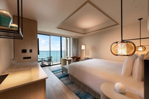 宫古岛Hilton Okinawa Miyako Island Resort的酒店客房设有一张床,享有海景。