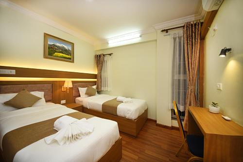 加德满都Green Hill Apartment Kathmandu的酒店客房配有两张床和一张书桌