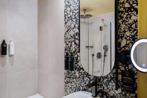 巴黎Hôtel Riesner的设有带镜子和水槽的淋浴的浴室