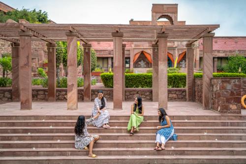 焦特布尔The Hosteller Heritage Palace, Jodhpur的坐在大楼前楼梯上的四个女人