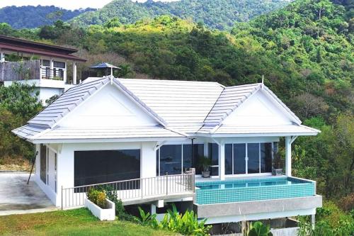 高兰BaanKuer Hill Pool Villa的山前带游泳池的白色房子