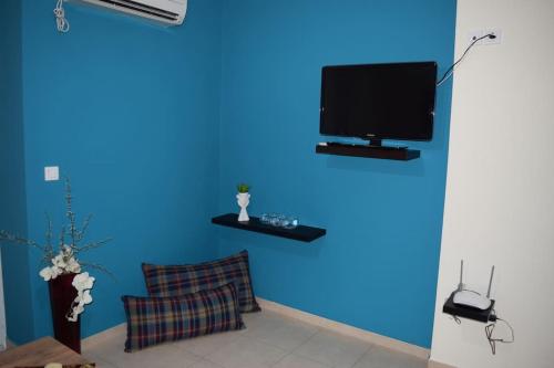 斯巴达Πολυτελές Διαμέρισμα με Θέα的蓝色的房间,蓝色的墙上配有电视