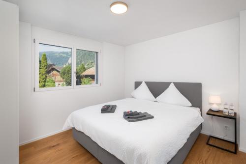 MattenNeubauwohnung mit Lift in Matten的白色的卧室设有床和窗户