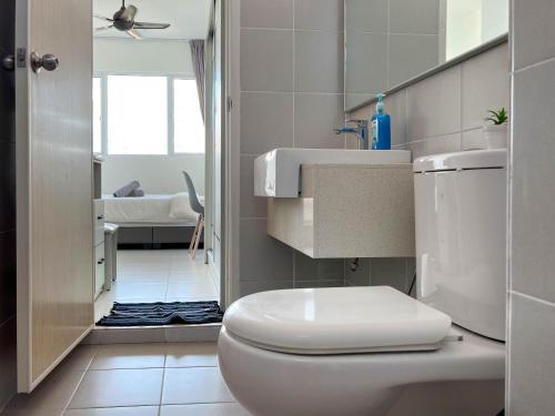 丹绒道光Seaview Private Master Bedroom in a Shared Unit的白色的浴室设有卫生间和水槽。