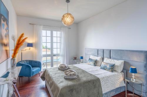 卡尼索VILLA LEONARDO的一间卧室配有一张大床和一张蓝色椅子
