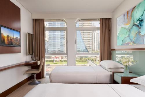 迪拜Villa Rotana的酒店客房设有两张床和大窗户。