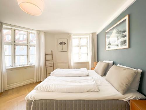 哥本哈根Large Flat with 4 Bedrooms in Copenhagen的一张大床,位于带两个窗户的房间