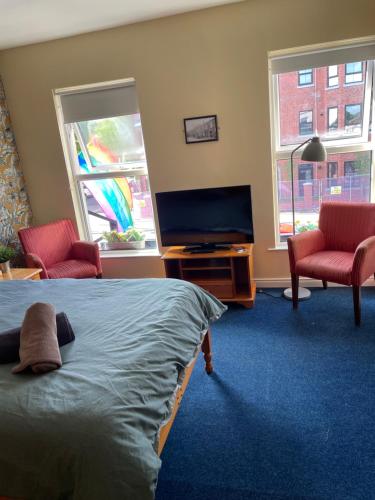 贝尔法斯特拉威尔奥缪旅馆的一间卧室配有一张床和一台平面电视
