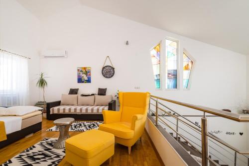 诺瓦利娅Resort Villa Moses的客厅配有黄色椅子和沙发