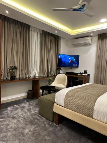 班加罗尔ROYAL ACE LUXUR的一间卧室配有一张床、一张书桌和一台电视。