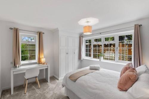 WorthingtonSilver Stag Properties, Luxurious 3 BR Bungalow的卧室配有一张床、一张书桌和窗户。