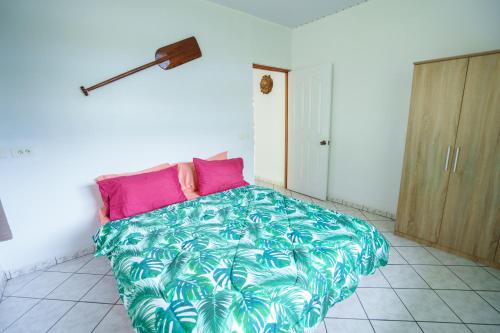 TohautuNoha Lodge的一间卧室配有一张大床,铺有粉色和绿色的床单。
