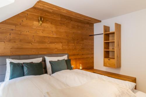 上陶恩Apartments Am Dorfplatzl的一间卧室设有一张带木墙的大床