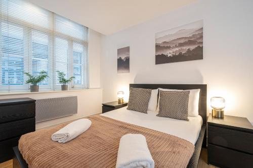 伦敦Turnmill Apartments的一间卧室配有一张大床和两个枕头