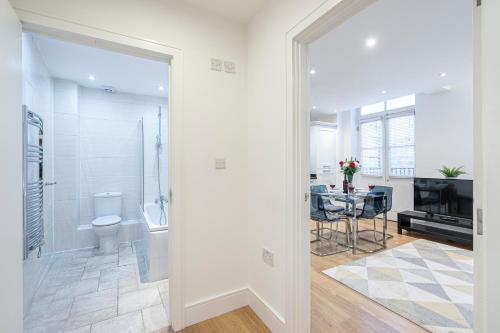 伦敦Turnmill Apartments的带淋浴、卫生间和桌子的浴室