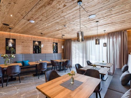 奥法赫Das Bergjuwel的餐厅设有木制天花板和桌椅