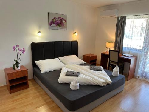 佐洛卡罗斯Boni Családi Wellness Hotel的一间卧室配有一张黑色床头板的床