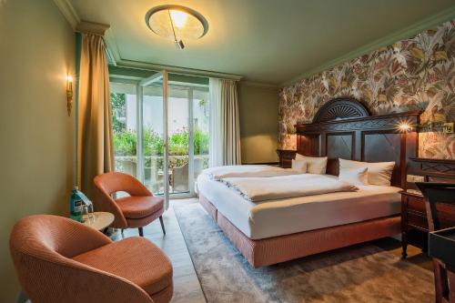 黑灵斯多夫黑灵斯多夫斯丹德酒店的一间卧室配有床、椅子和窗户