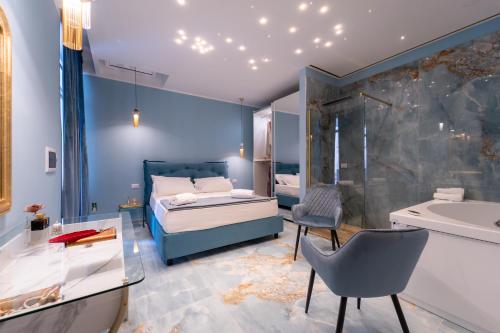 加利波利Suite Acquamarina Relais Stapane的一间卧室配有一张床,浴室设有浴缸