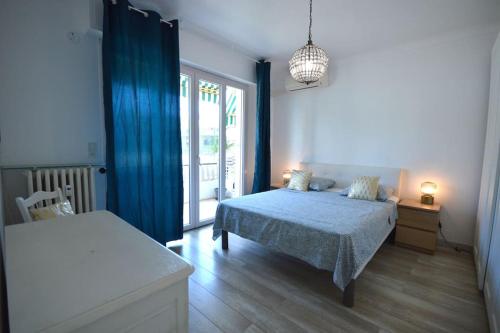 戛纳Le Madrilien & Terrasse & Clim & 400M Croisette的一间卧室配有一张带蓝色毯子的床和窗户。